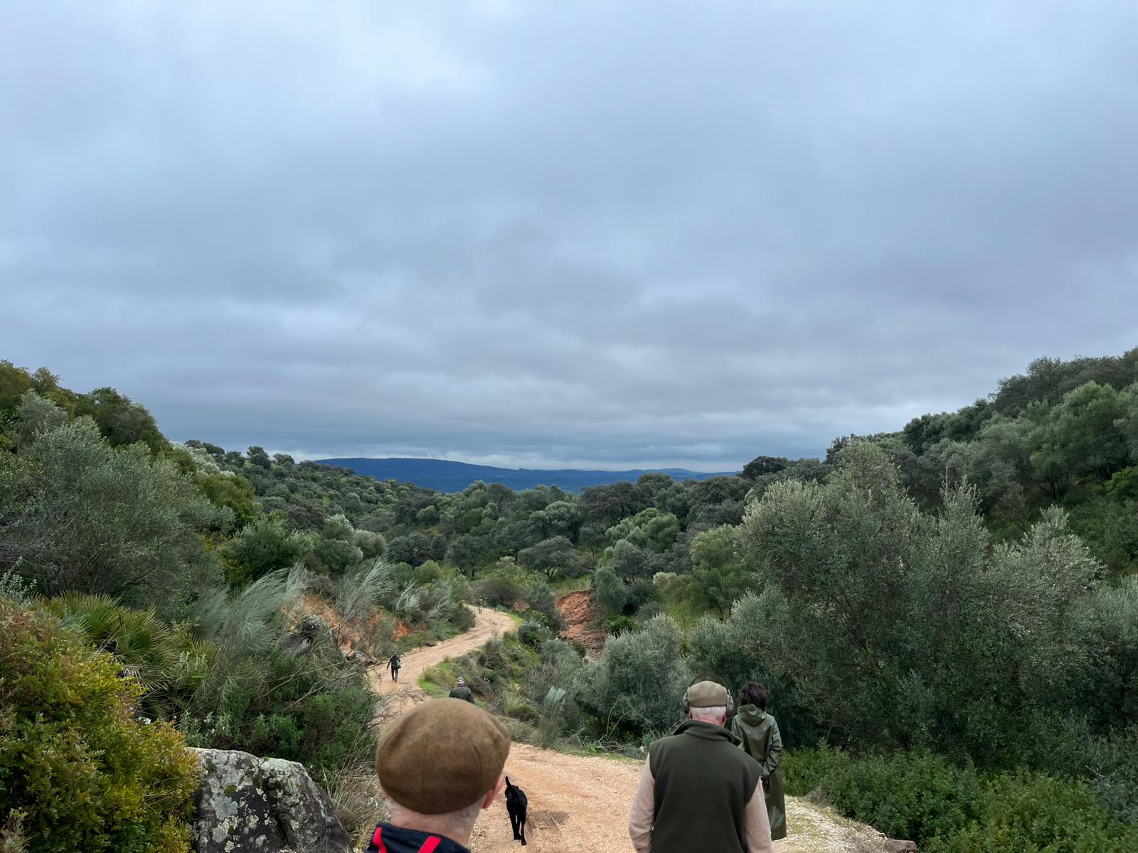 Team of guns walking down a winding track through the Spanish countryside