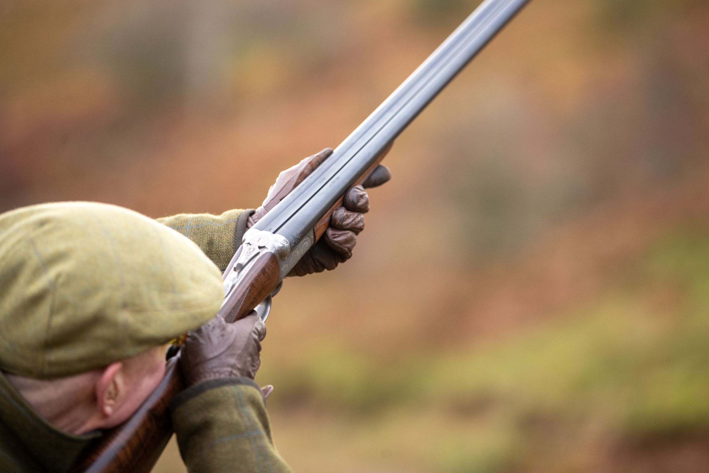 Close up of someone aiming a rifle on a driven game shoot in Scotland